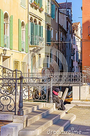 Bridge, canal and a tourist reading, in Venice Editorial Stock Photo