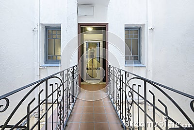 Bridge corridor of a house with wrought iron balustrades and access to an elevator with a metal and glass structure Stock Photo