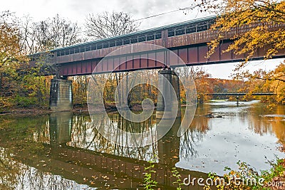 The Bridge of Dreams is a covered Bridge spanning over Mohican river in a fall season Stock Photo