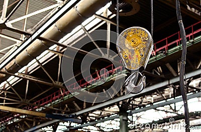 Bridge lifting Crane Hook against the background of the Assembly Line industrial factory. Stock Photo
