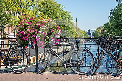 Bridge over canal with bicycles and flowers, Amsterdam, the Nethelands Stock Photo
