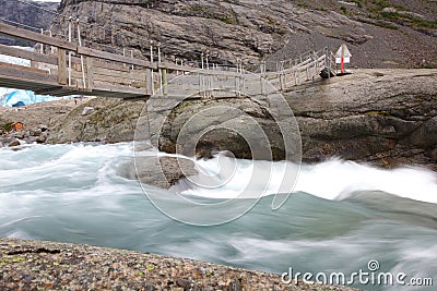 Bridge over rapid runoff water from glacier Stock Photo