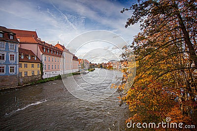 a bridge over a river with a building in the background and a clock tower on top of it, Stock Photo