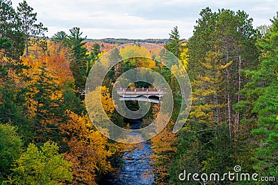 Bridge over a river in a colorful autumn woodland Stock Photo