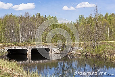 Bridge over a small river forest made of reinforced concrete channels Stock Photo