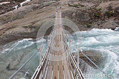 Bridge over troubled glacial water Stock Photo