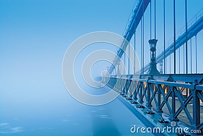 Bridge vanishing in heavy blue fog Editorial Stock Photo