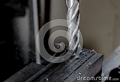 CNC end mill finishing a stack of steel plate with metal filings chips trailing Stock Photo