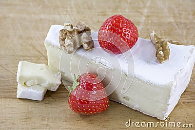 Brie cheese with walnuts and strawberries on wooden background Stock Photo