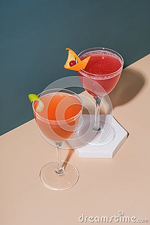 Bright alcoholic cocktails in steamed glasses on podiums or pedestal Stock Photo