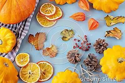 Bright autumn background. Top view of a white and brown checked kitchen towel, orange pumpkin, yellow squash, autumn leaves, Stock Photo