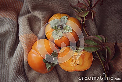bright background. ripe orange persimmon on a beige background. beautiful background texture. juicy fruits. vitamins Stock Photo