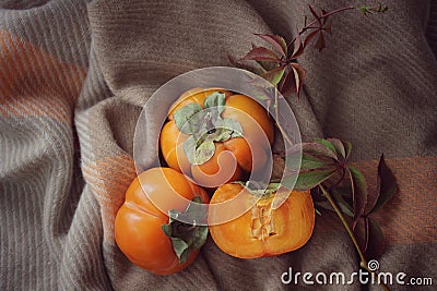 bright background. ripe orange persimmon on a beige background. beautiful background texture. juicy fruits. vitamins Stock Photo