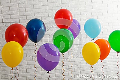 Bright balloons near wall. Celebration time Stock Photo