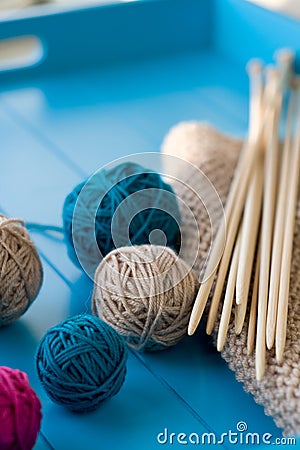 Bright balls of yarn, wooden knitting needles, knitted blanket Stock Photo