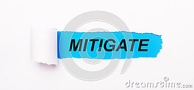 On a bright blue background, white paper with a torn stripe and the text MITIGATE Stock Photo