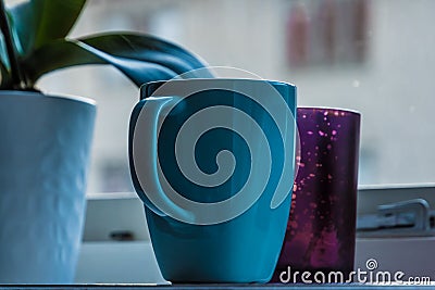 Bright blue cup standing on window board Stock Photo