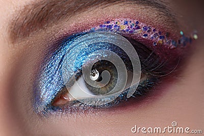 Bright blue evening eyelid makeup with multi-colored sparkles Stock Photo