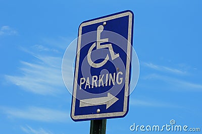 Bright blue handicapped parking sign against blue sky Stock Photo