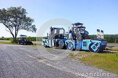 Bright blue road construction machinery parked Editorial Stock Photo