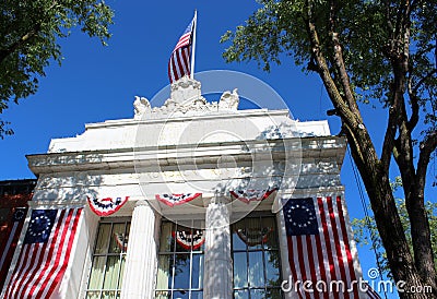 Bright blue sky behind Historic architecture covered in flags, Adirondack Trust, Saratoga, New York, 2018 Editorial Stock Photo