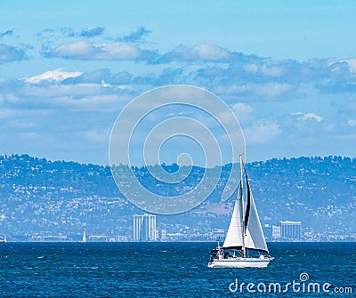 Sailboat on a sunny day with blue water and blue sky Stock Photo