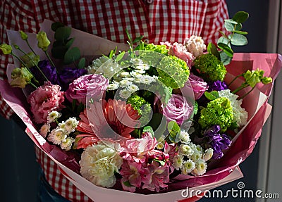 A bright bouquet of fresh flowers in the hands of a young girl Stock Photo