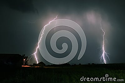 Bright branched lightning bolts hit the earth in the foothills of the Carpathian Mountains in Romania Stock Photo