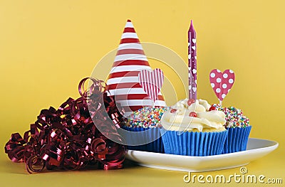 Bright and cheery red blue and yellow theme cupcakes with birthday candle Stock Photo