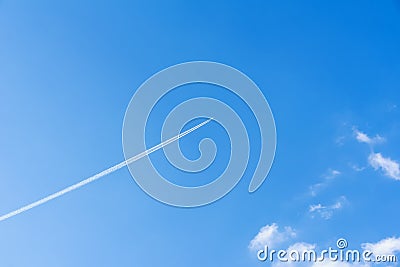 Bright clear blue sky background with diagonal jet plane trace, track, Airplane trace, condensation trails, vapor trails Stock Photo