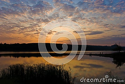 Bright cloudy sunset above the lake Stock Photo