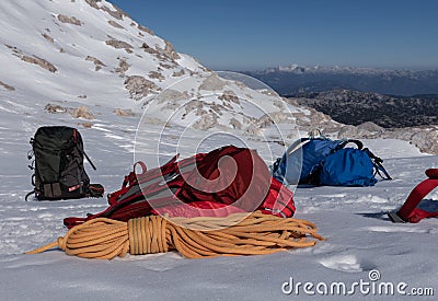 Bright colored backpacks and a rope lie on a snowy slope, Austria, Alps, Dachstein Stock Photo