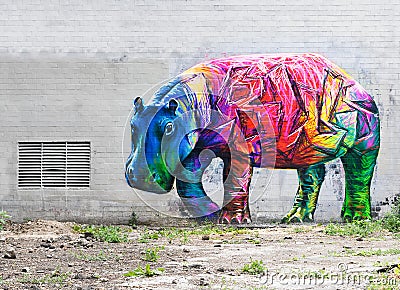 Bright colored hippopotamus graffiti on a gray brick wall. Editorial Stock Photo