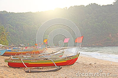 Bright colorful boats with flags for catching fish stood on the shore of the Indian Ocean. India, Goa Editorial Stock Photo