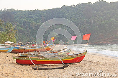Bright colorful boats with flags for catching fish stood on the shore of the Indian Ocean. India, Goa Editorial Stock Photo