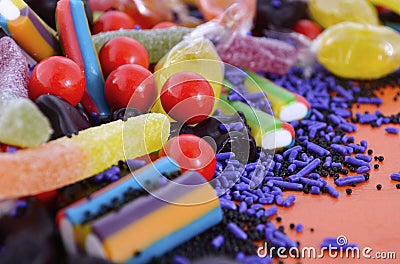 Bright colorful candy on orange wood background. Stock Photo