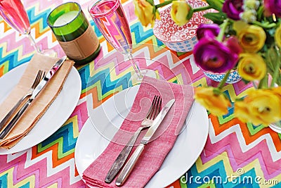 Bright colorful table setting with chevron tablecoth Stock Photo
