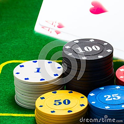 Bright columns of poker chips behind which falls a pair of aces Stock Photo