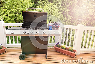 Bright daylight on deck wiht open barbecue cooker and bottled be Stock Photo