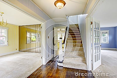 Bright entry way to home with carpet stairs and two room interiors with yellow and blue walls. Stock Photo