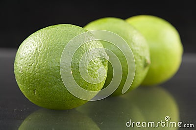 Bright fresh green limes on dark background Stock Photo