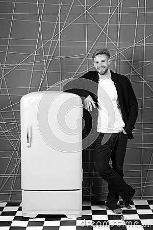 Bright fridge household appliances interior object. Designer adding accent to interior. Man lean retro vintage yellow Stock Photo