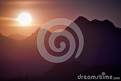 Bright Glare of Sunset silhouette mountains Stock Photo