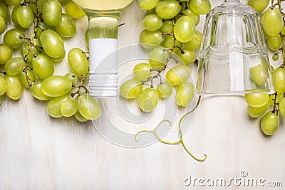 Bright grapes with a bottle of white wine and glass on rustic a white wooden background Stock Photo