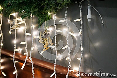 Bright hanging garland lights with wooden skates figure and fir branches Stock Photo