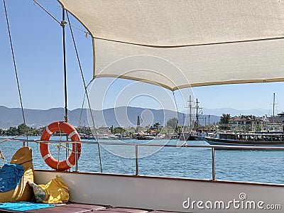 A bright lifebuoy on board the yacht. Railings of a sea ship against the background of the sea and mountains. A circle for Stock Photo