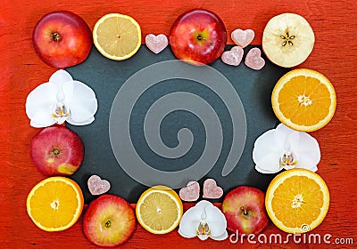 Bright multicolored background frame with citrus lemon, orange, cutting the apples, jelly sweets in the shape of a heart Stock Photo