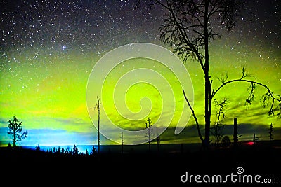 Bright northern lights and starry sky over lapland landscape Stock Photo