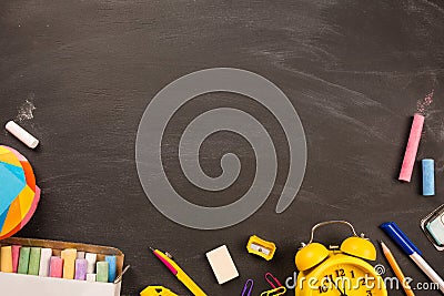 Bright office supplies, yellow alarm clock on black chalkboard top view, copy space. concept: back to school Stock Photo