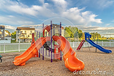 Bright orange and blue slides at a colorful fun playground for children Stock Photo